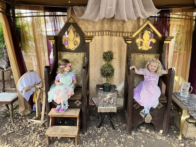 Two children on decorative thrones at the Renaissance Festival in 2024